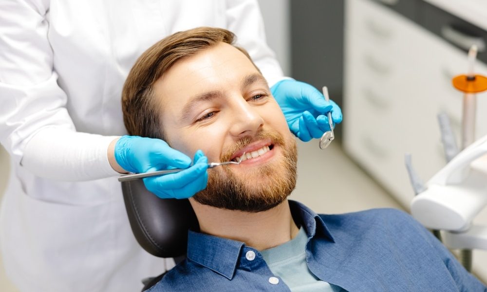 Portrait,Of,Happy,Man,Sitting,At,Dentist,Chair,In,Modern